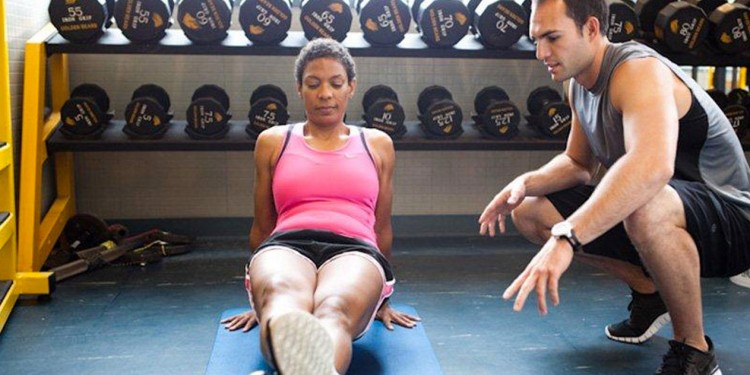 client foam rolling in front of a corrective exercise specialist